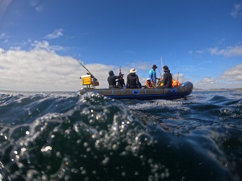 Group of 8 people on the boat on a spearfishing trip